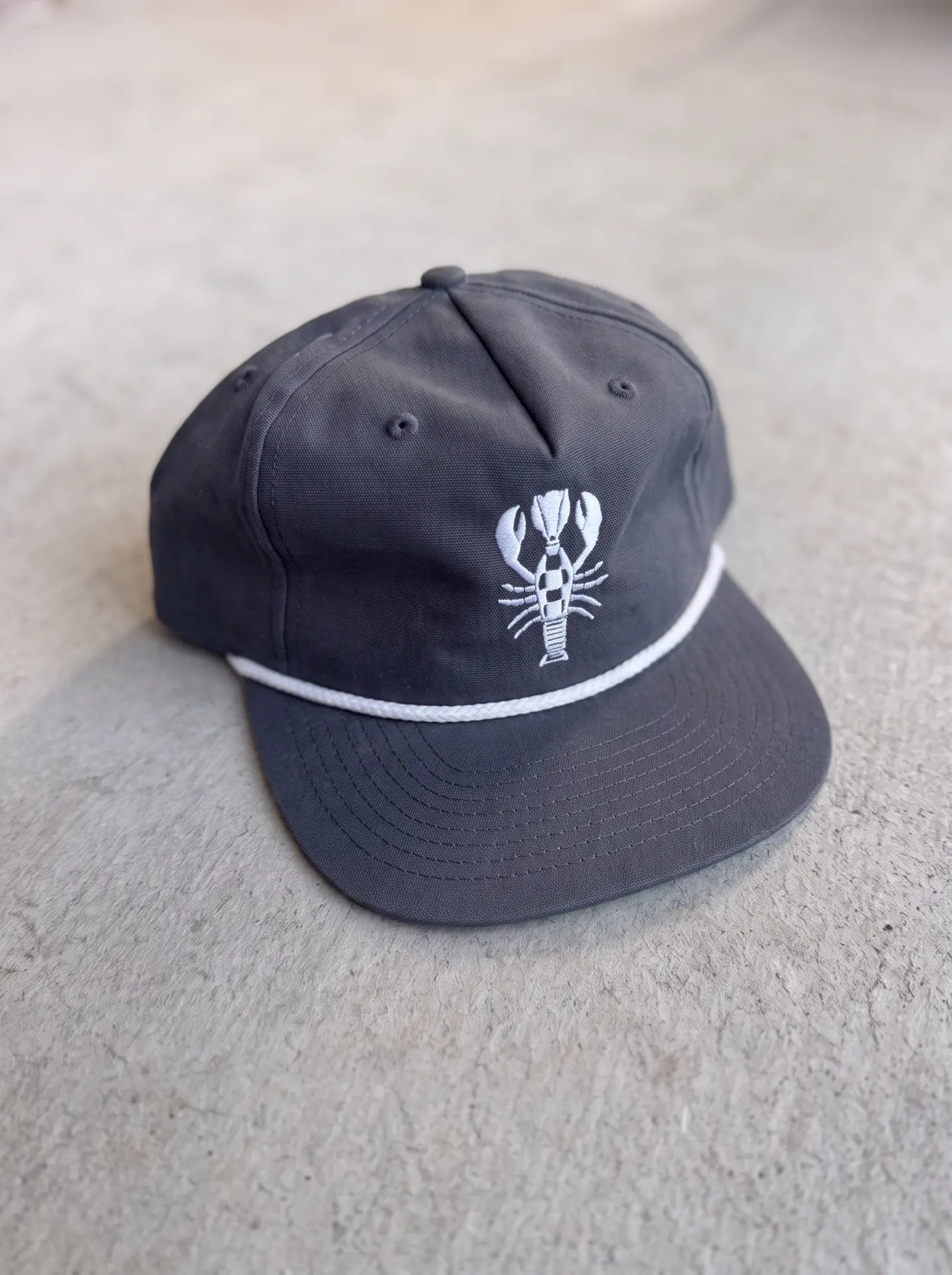 Navy rope cap with white rope brim and embroidered lobster