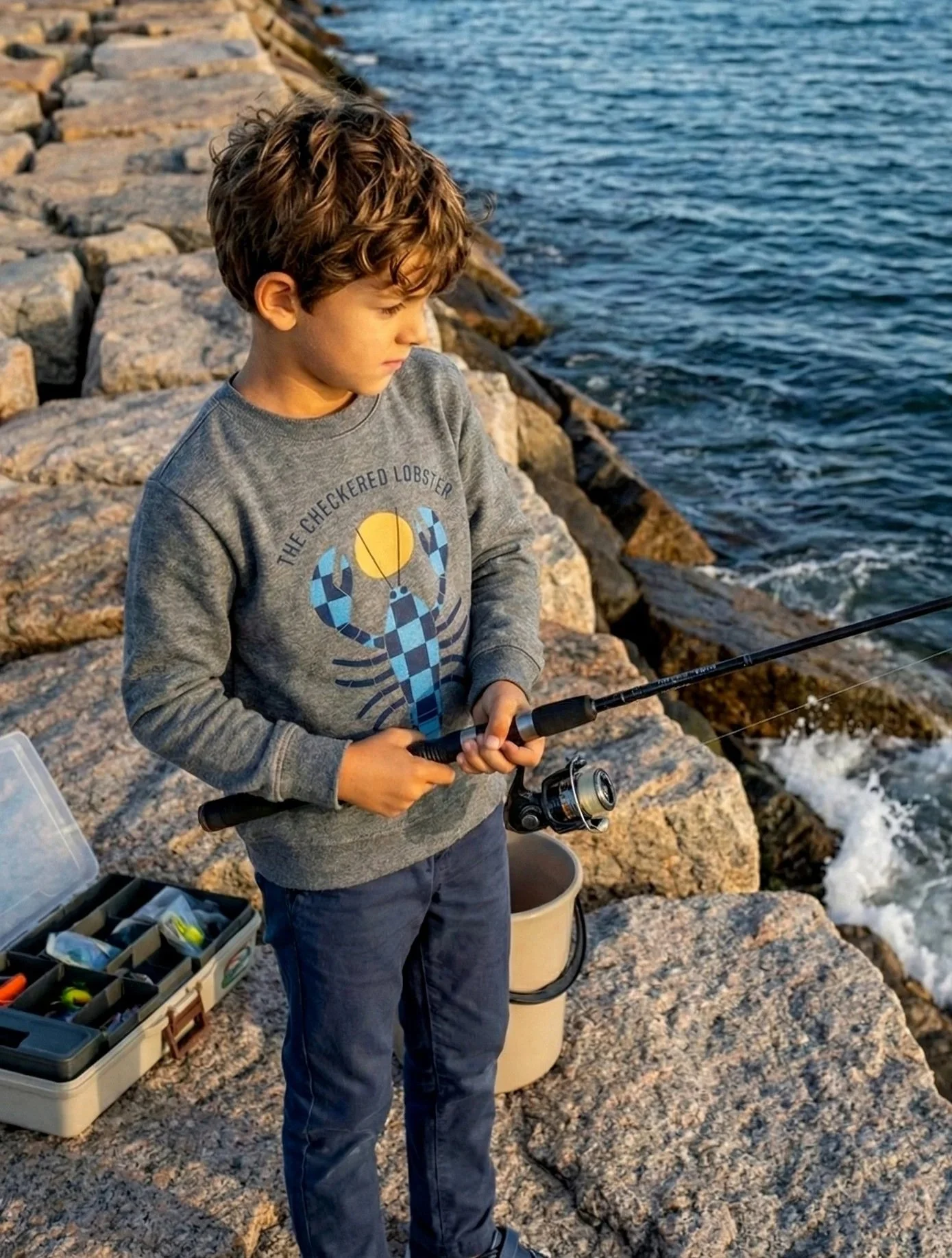 Boy fishing on a jetty in a Checkered Lobster crewneck